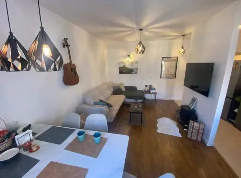 Dnevna soba sa trpezarijom, garniturom za sjedenje i TV-om na zidu. - image 5