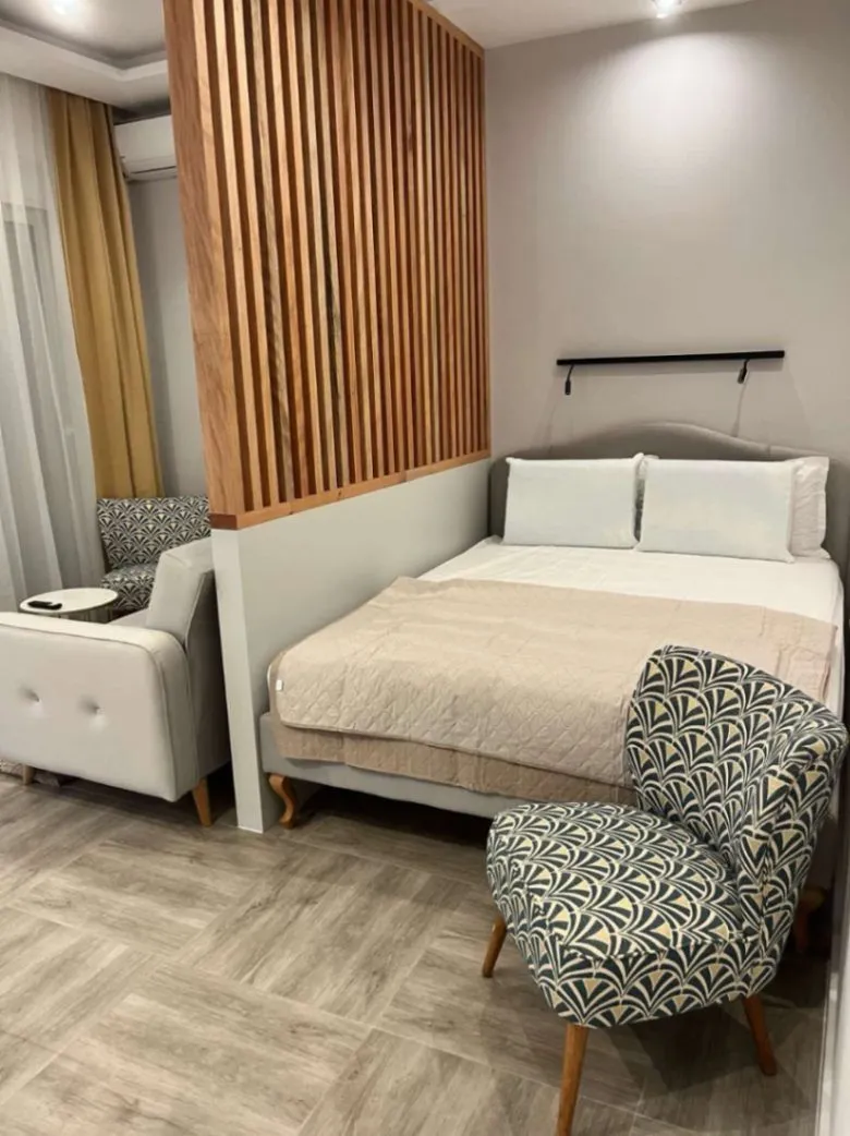 Modern bedroom with a double bed and a wooden partition screen.