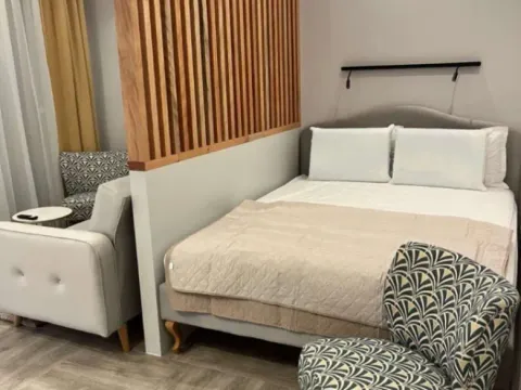 Modern bedroom with a double bed and a wooden partition screen. - image 6