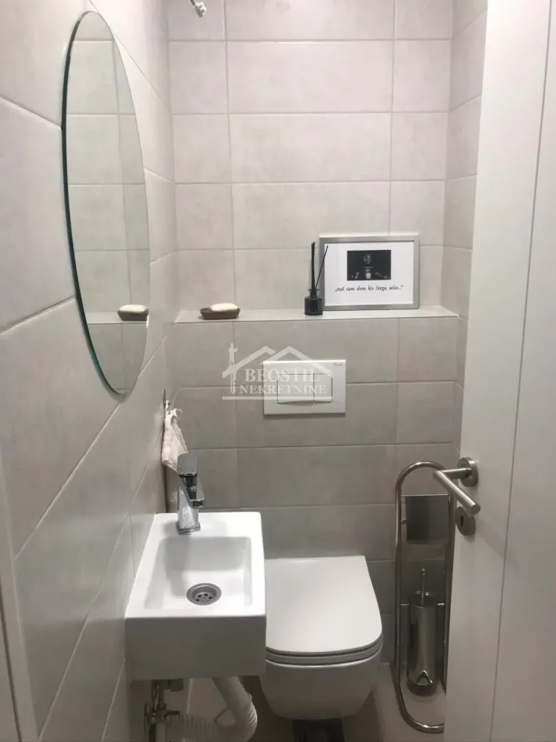 Manje kupatilo sa umivaonikom, WC šoljom i ogledalom.