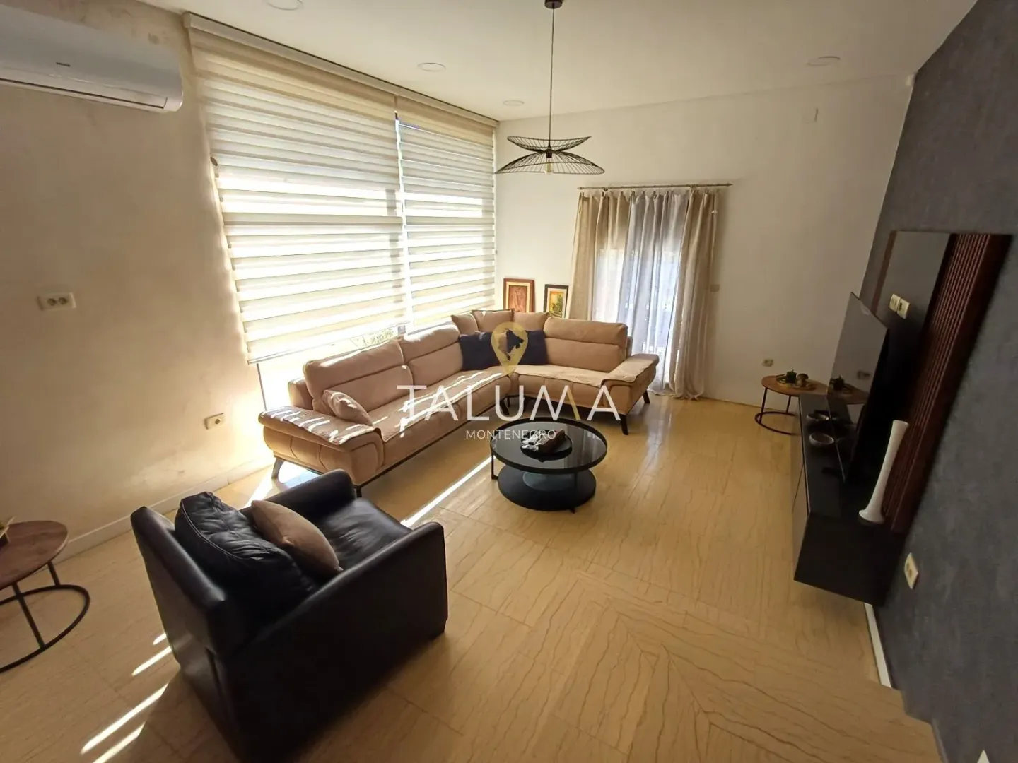 Spacious living room with a sofa set and a television.