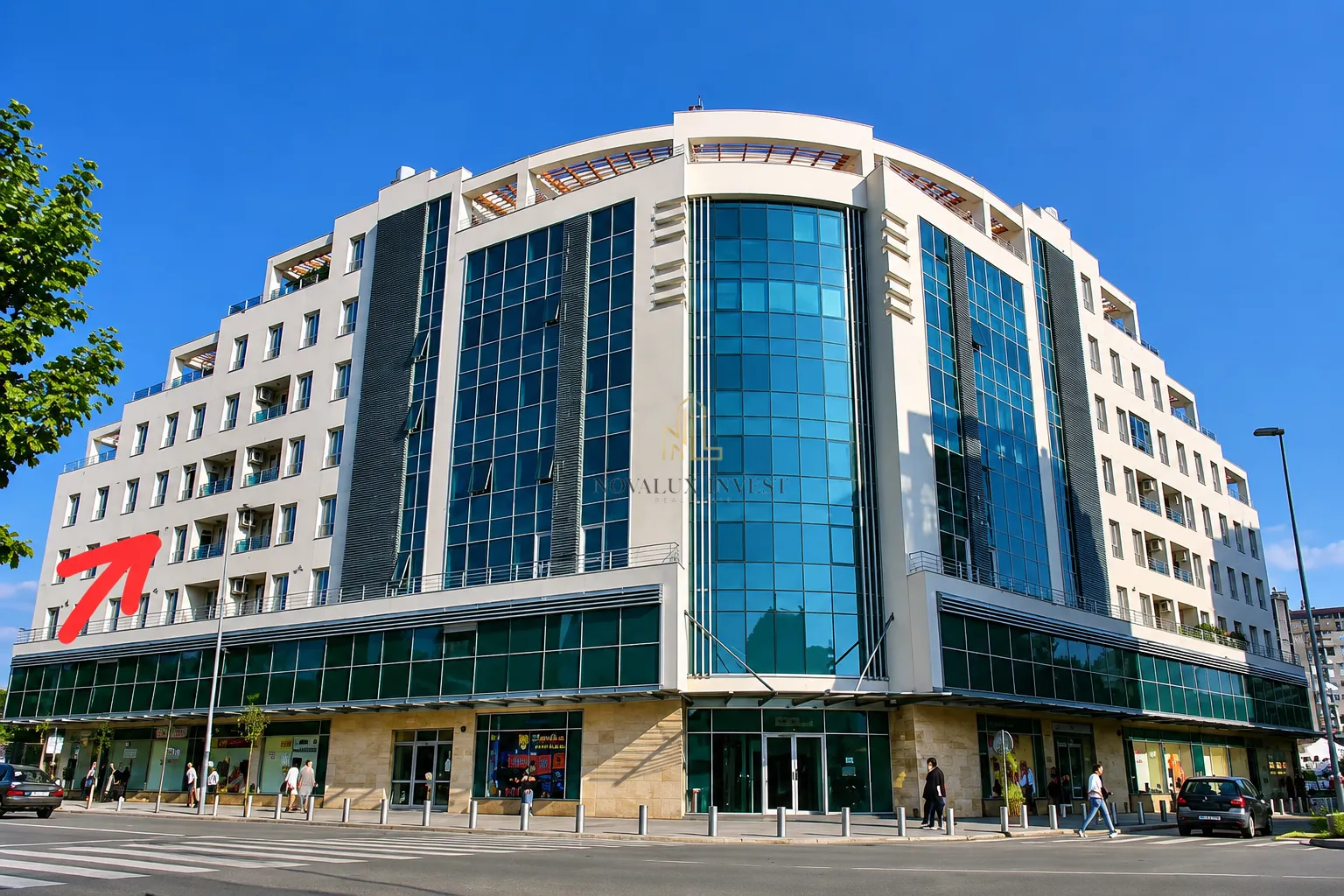 Pogled na spoljašnjost moderne poslovno-stambene zgrade sa velikim staklenim površinama.