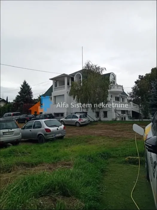 View of the exterior of the house with a yard and parked cars.