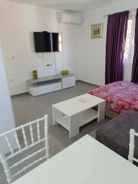 Furnished bedroom with a bed, TV, and air conditioning unit. - image 2