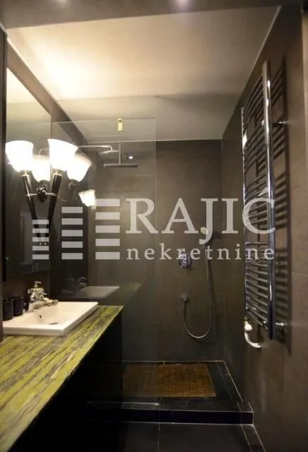 Modern bathroom with a walk-in shower and washbasin.
