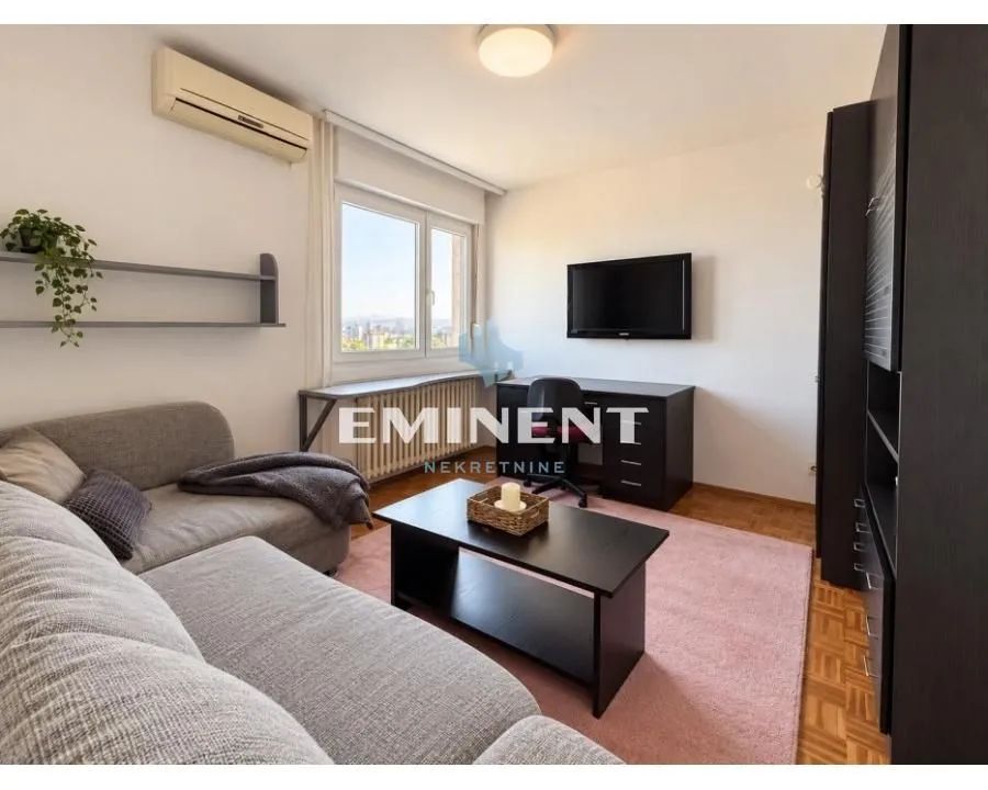Living room with a sofa, desk, and television.