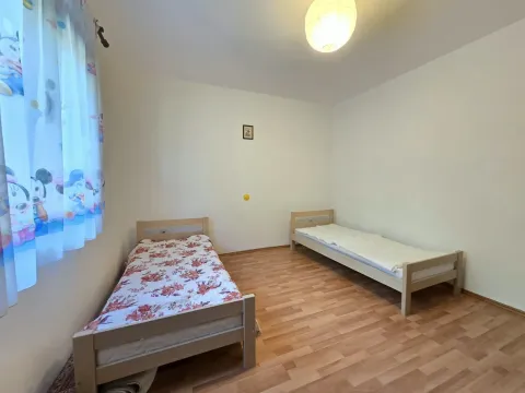 Spavaća soba sa dva kreveta i laminatom na podu. - image 6