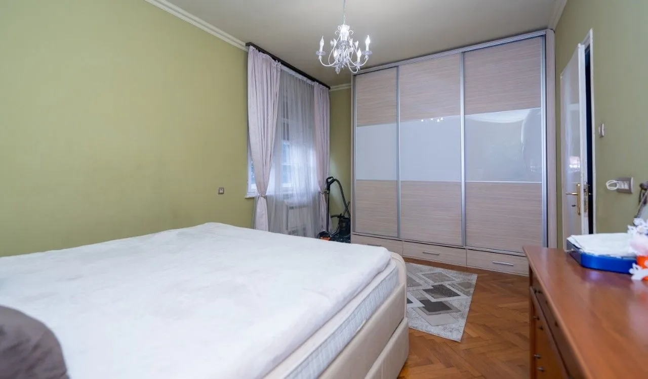 Bedroom with a double bed, large built-in wardrobe, and a window.