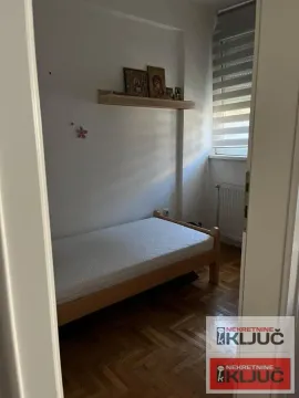 Smaller bedroom with a bed and a wall shelf. - image 5