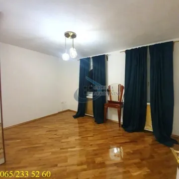 Prazna soba sa parketom i tamnim zavesama na prozorima. - image 4