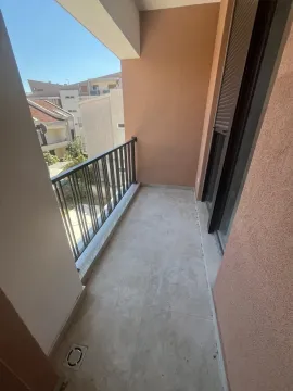 Nenamješten balkon sa metalnom ogradom i pogledom na naselje. - image 7