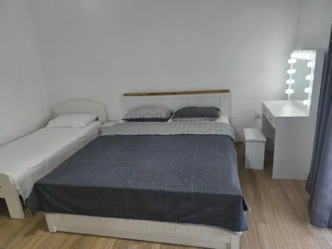 Bedroom with a large double bed, an extra single bed, and a vanity table. - image 7