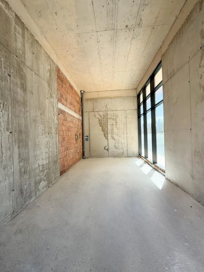 Unfinished room in grey phase with a large window.