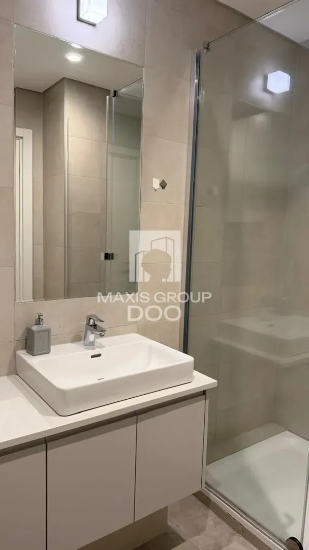Modern bathroom equipped with a washbasin and a walk-in shower.