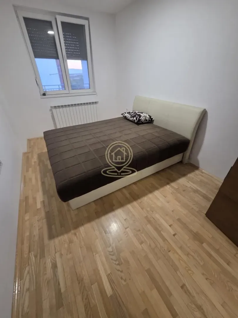 Spavaća soba sa bračnim krevetom i prozorom.