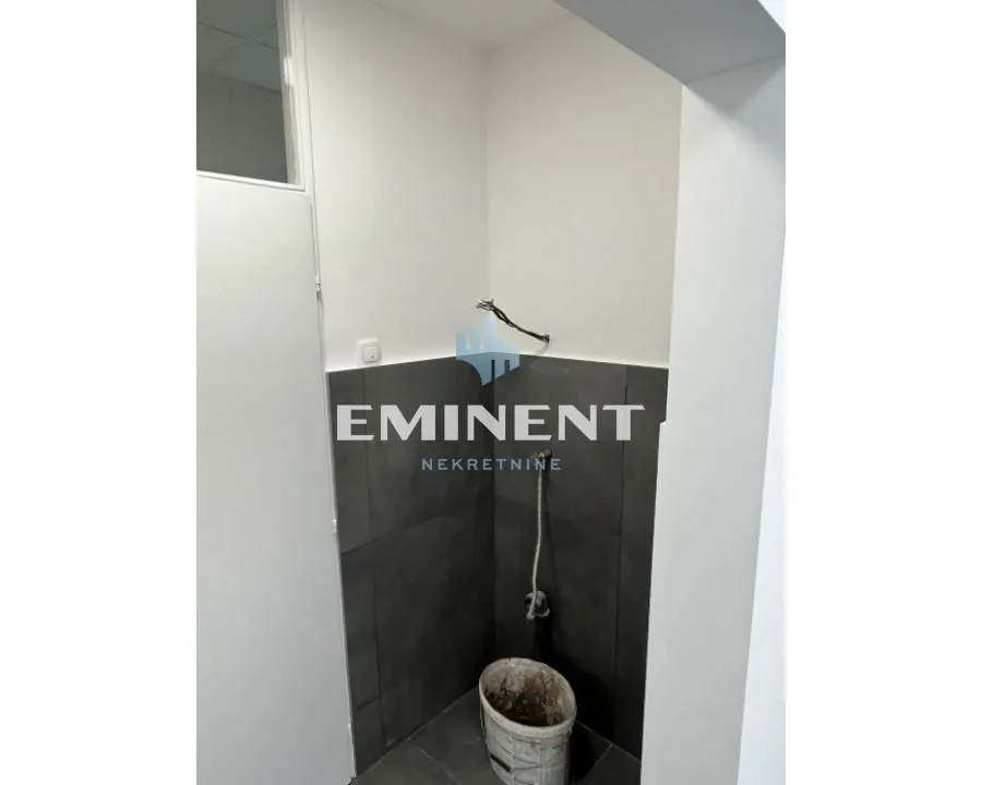 Bathroom under renovation with dark tiles on the lower part of the wall.