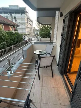 Uređena terasa sa stolom, stolicama i sušilicom za veš. - image 5