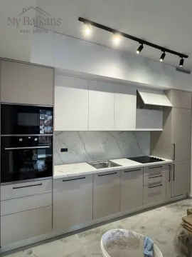 Modern kitchen with built-in appliances and a marble backsplash. - image 3