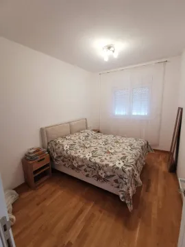 Spavaća soba sa bračnim krevetom, noćnim stočićem i prozorom. - image 3