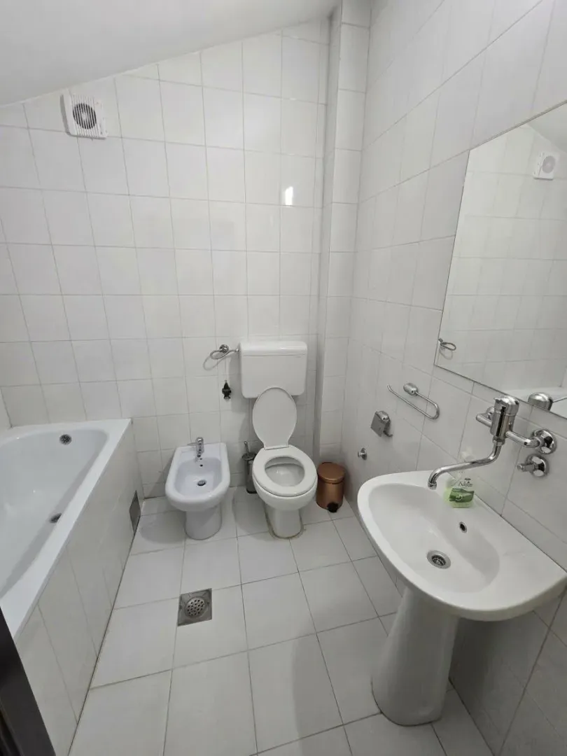 Bright equipped bathroom with a bathtub, washbasin, and sanitary fixtures.