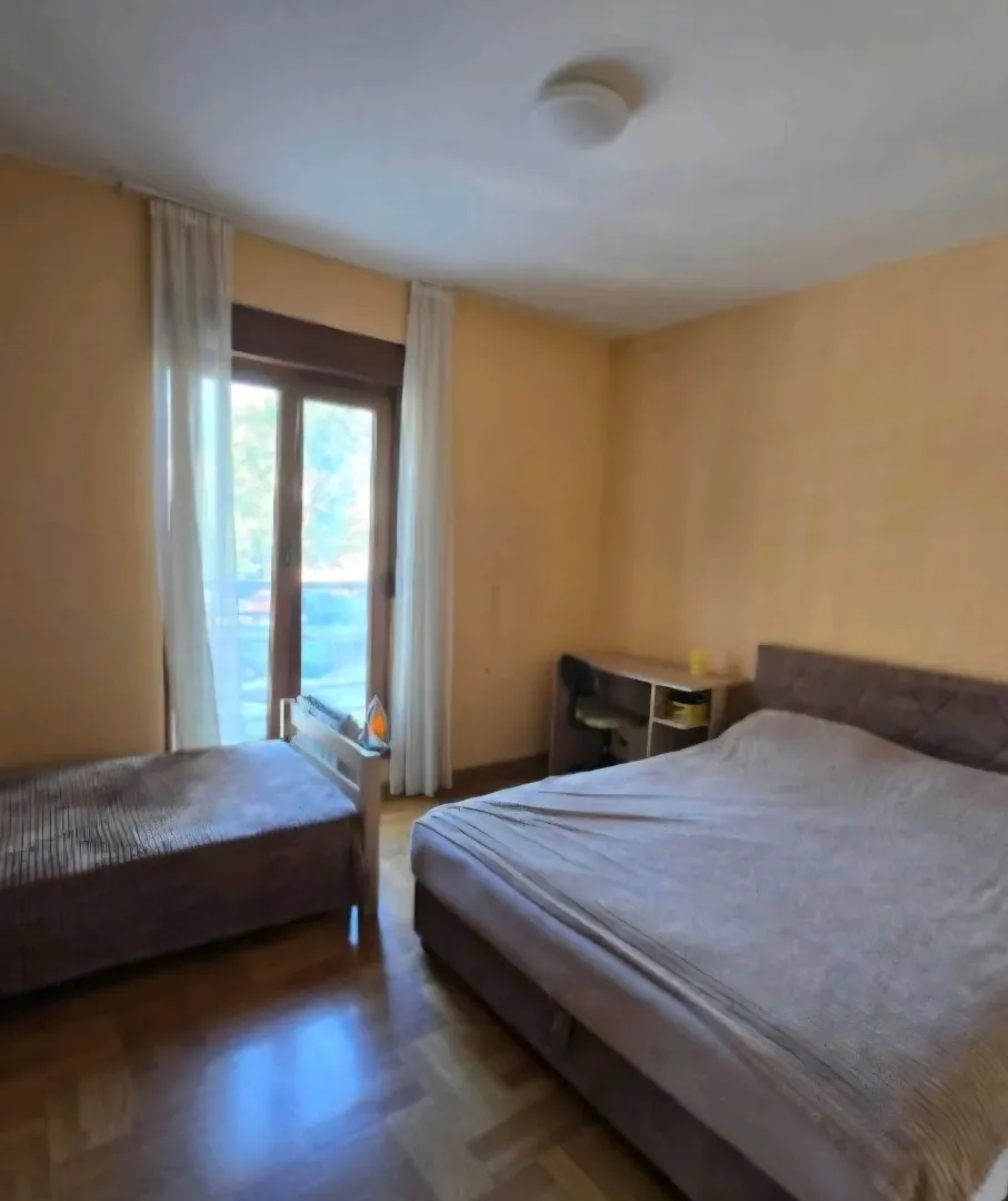 Bedroom with a double bed, a smaller bed, and a desk.