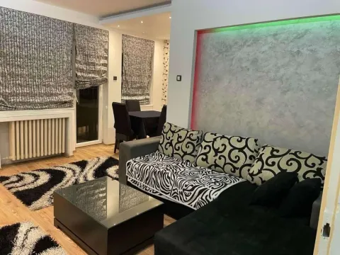 Living room with a sofa and a dining area in the background. - image 2