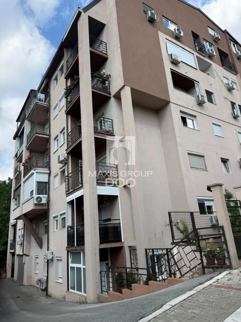 Pogled na spoljašnjost višespratne stambene zgrade sa terasama.