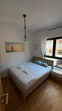 Small bedroom with a double bed, wooden floor and a window. - image 10