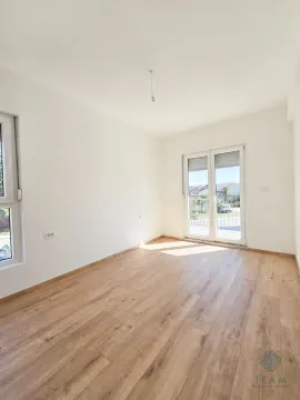 Prazna soba sa svijetlim drvenim podom, bijelim zidovima i izlazom na terasu. - image 3