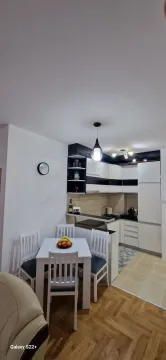 Modern kitchen with dining area and white cabinets. - image 4