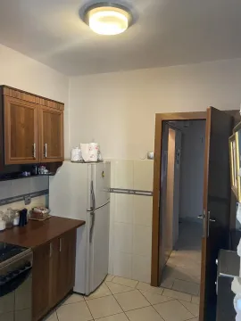 Kitchen with wooden cabinets, a refrigerator, and a view of the hallway. - image 3