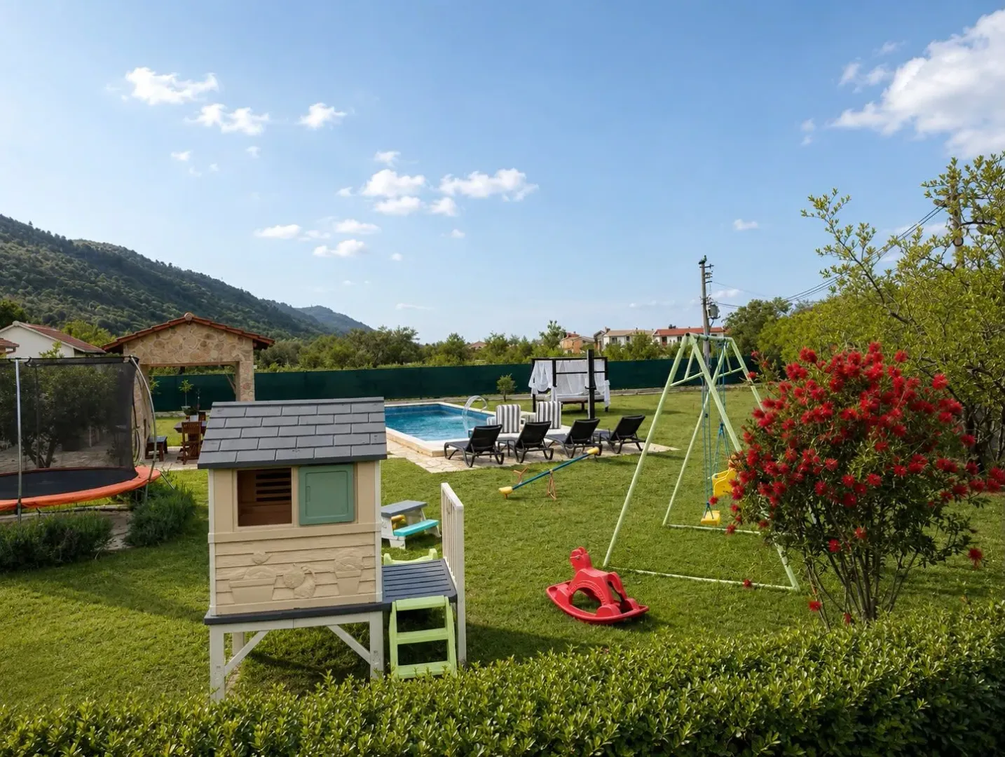 Landscaped yard with a swimming pool, children's playground, and gazebo.
