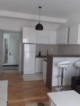 Small white kitchen with a breakfast bar and bar stools. - image 2