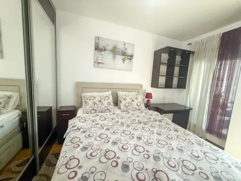 Furnished bedroom with a double bed, wardrobe, and desk. - image 4