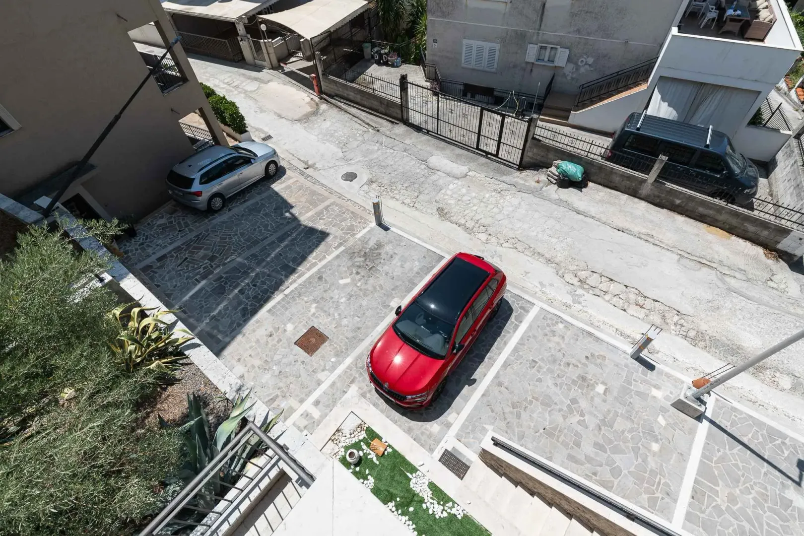 Pogled odozgo na popločani parking prostor ispred zgrade.
