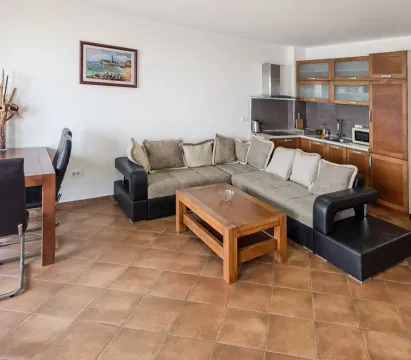 Otvoreni dnevni boravak sa ugaonom garniturom, trpezarijom i ugrađenom kuhinjom. - image 2