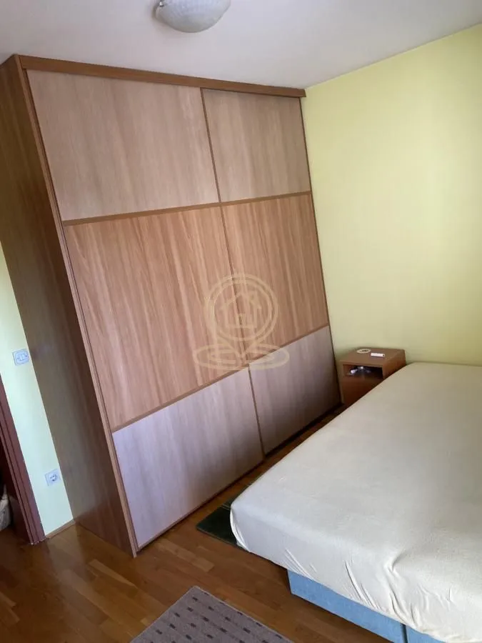Bedroom with a bed and a large wooden wardrobe.