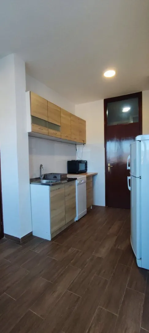 A simple and functional kitchen with wooden cabinets.