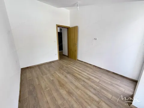 Prazna soba sa bijelim zidovima i drvenim podom. - image 6