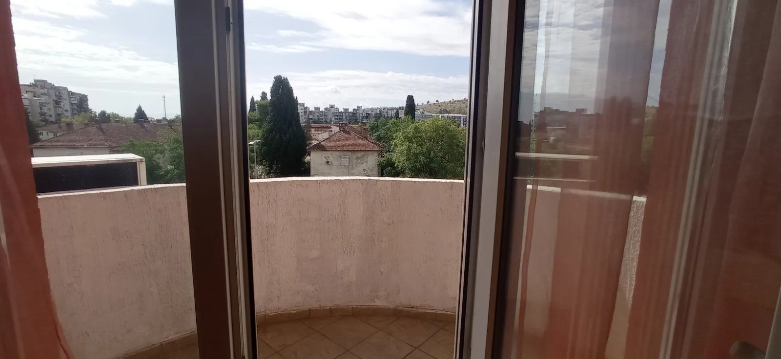 View from the balcony overlooking the surrounding neighborhood and trees.