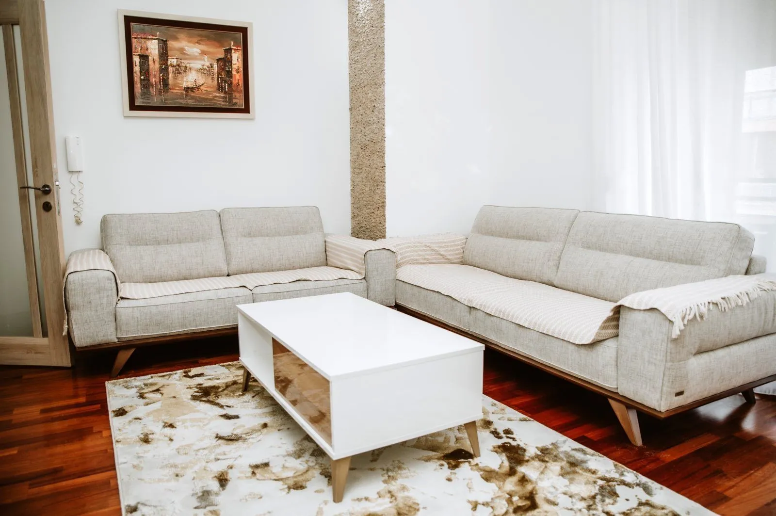 Bright living room with two grey sofas and a white coffee table.