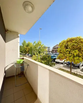 View from the balcony towards the parking lot and surrounding greenery. - image 3