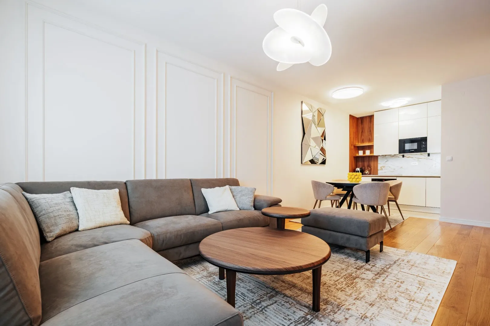 Living room with sofa set and view of the kitchen and dining area.