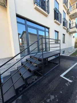 Exterior of a commercial space with metal stairs and glass entrance doors. - image 3