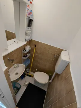 Small bathroom with a sink, toilet, and mirror. - image 7