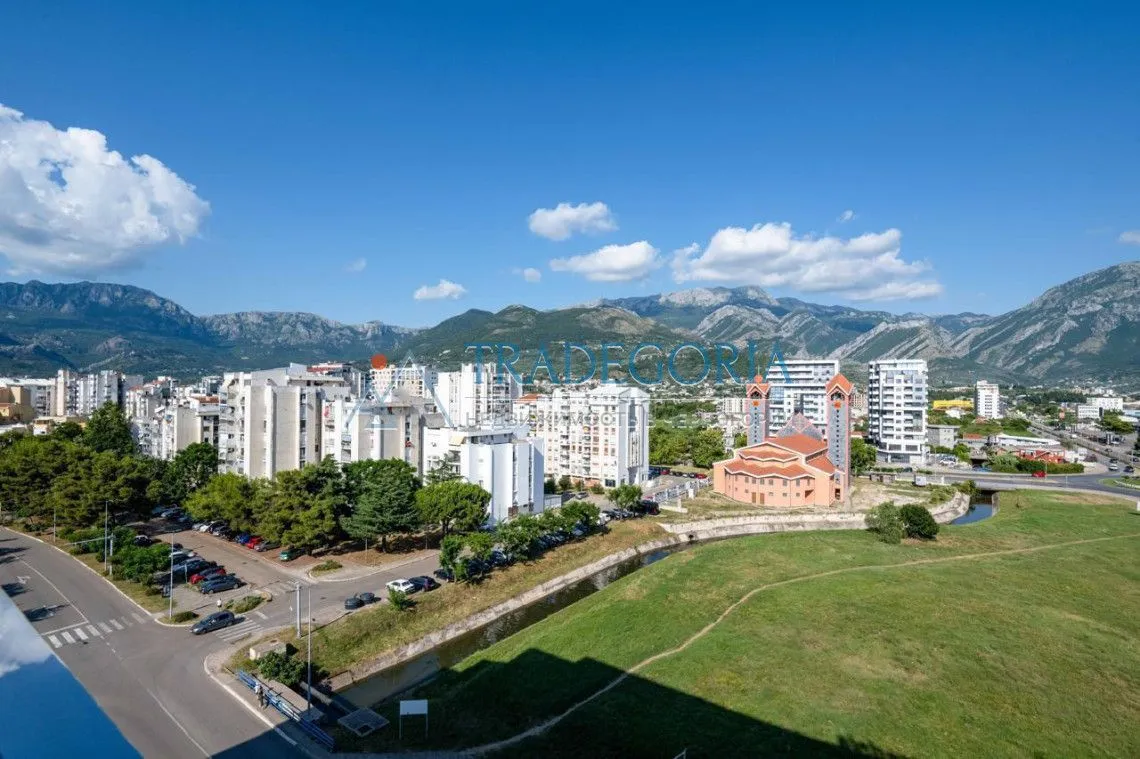 Pogled na grad sa planinama u pozadini.