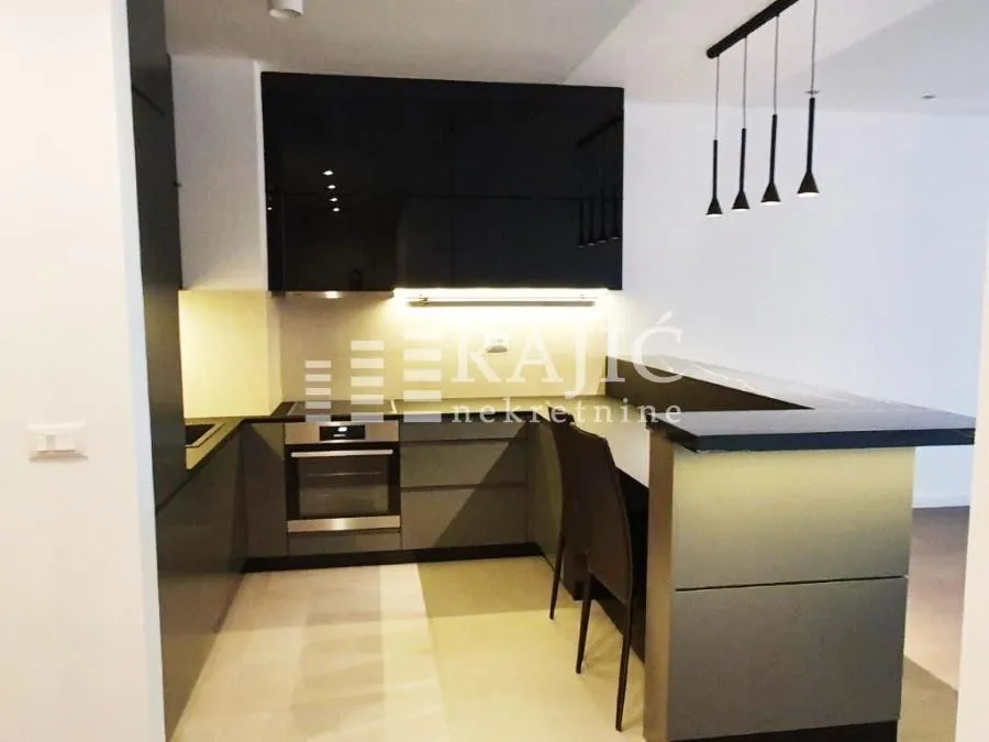 Modern kitchen with dark cabinetry and a breakfast bar.