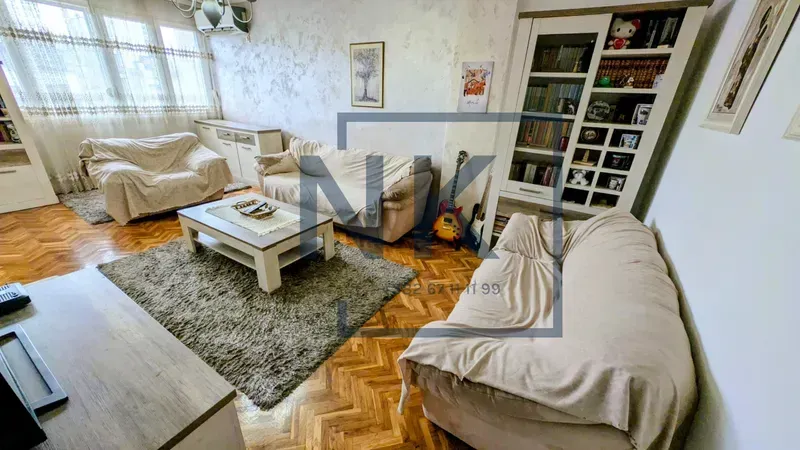 Living room with a sofa set, coffee table, and bookcase.