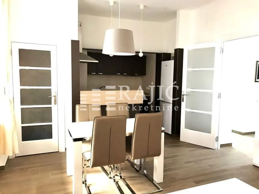 Living room with dining area and view of the kitchen.