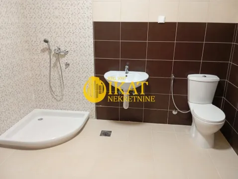 Bathroom equipped with a shower cabin, washbasin, and toilet. - image 11